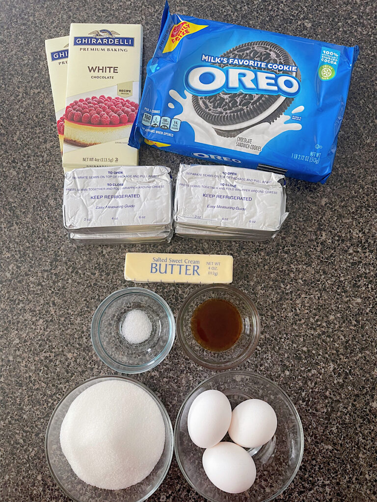 Ingredients to make white chocolate cheesecake with chocolate cookie crust.
