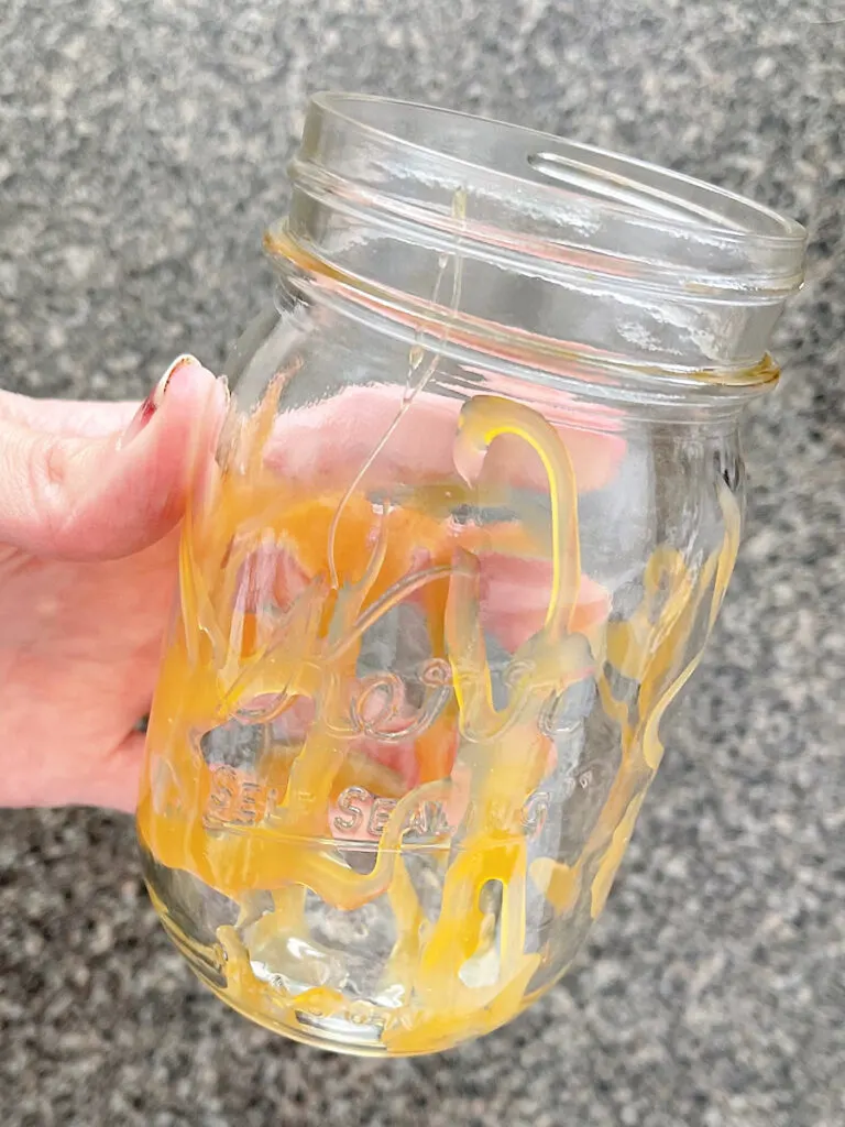 Caramel drizzled on the inside of a mason jar.