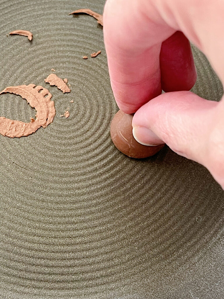 Melting the bottom of a Hershey kiss in a hot pan.