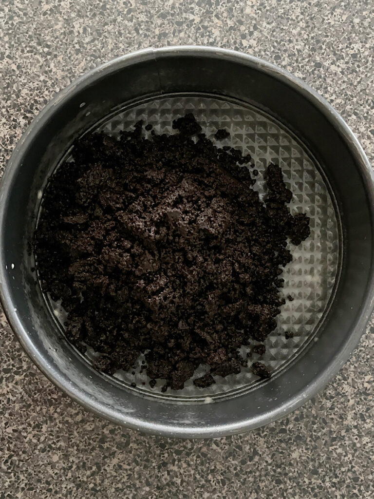 Oreo crumbs in a springform pan.