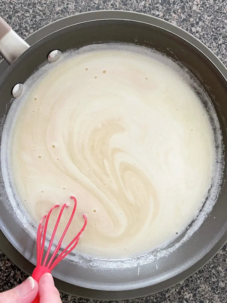Buttermilk syrup in a pan with a whisk.