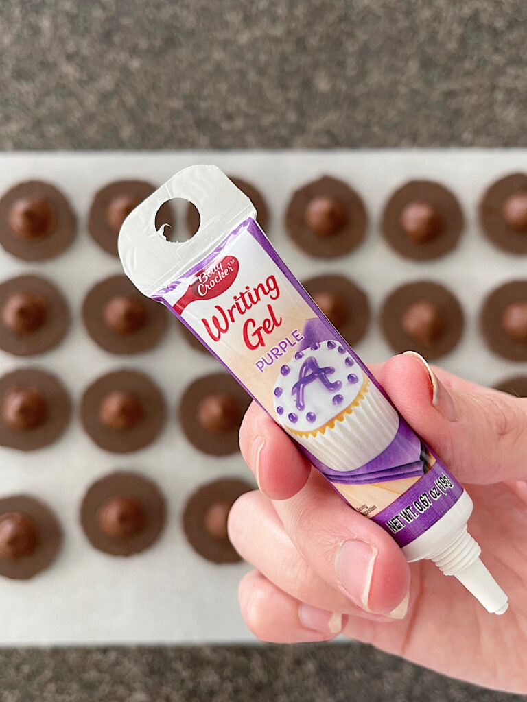 Writing gel icing to make Halloween witch hat cookies.