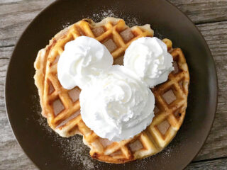 An overnight yeast waffle that tastes like a funnel cake topped with a Mickey Mouse-shaped whipped cream.