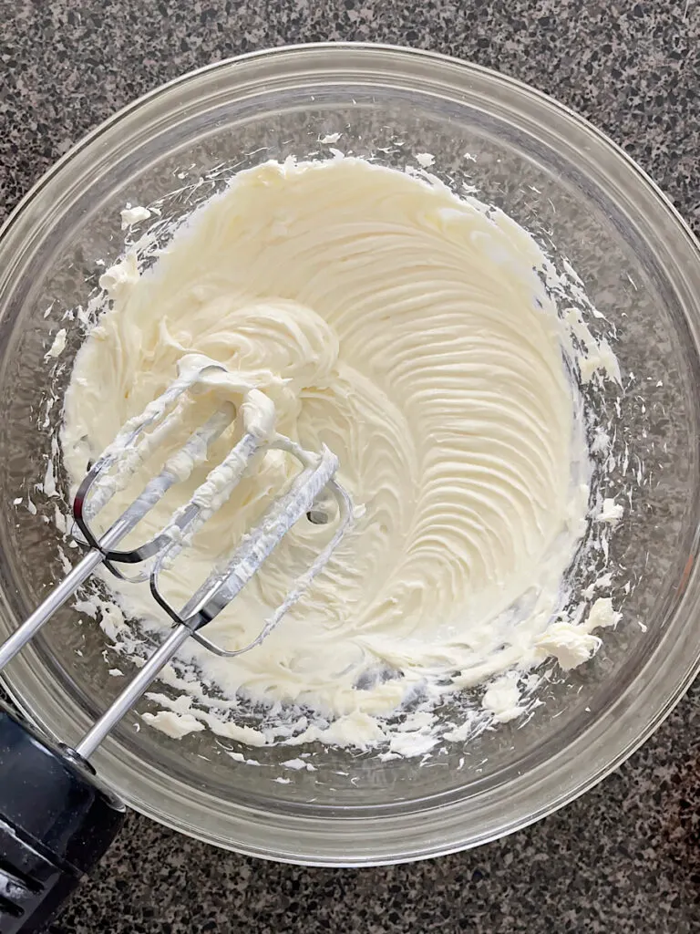 A bowl of cream cheese mixed with sugar.