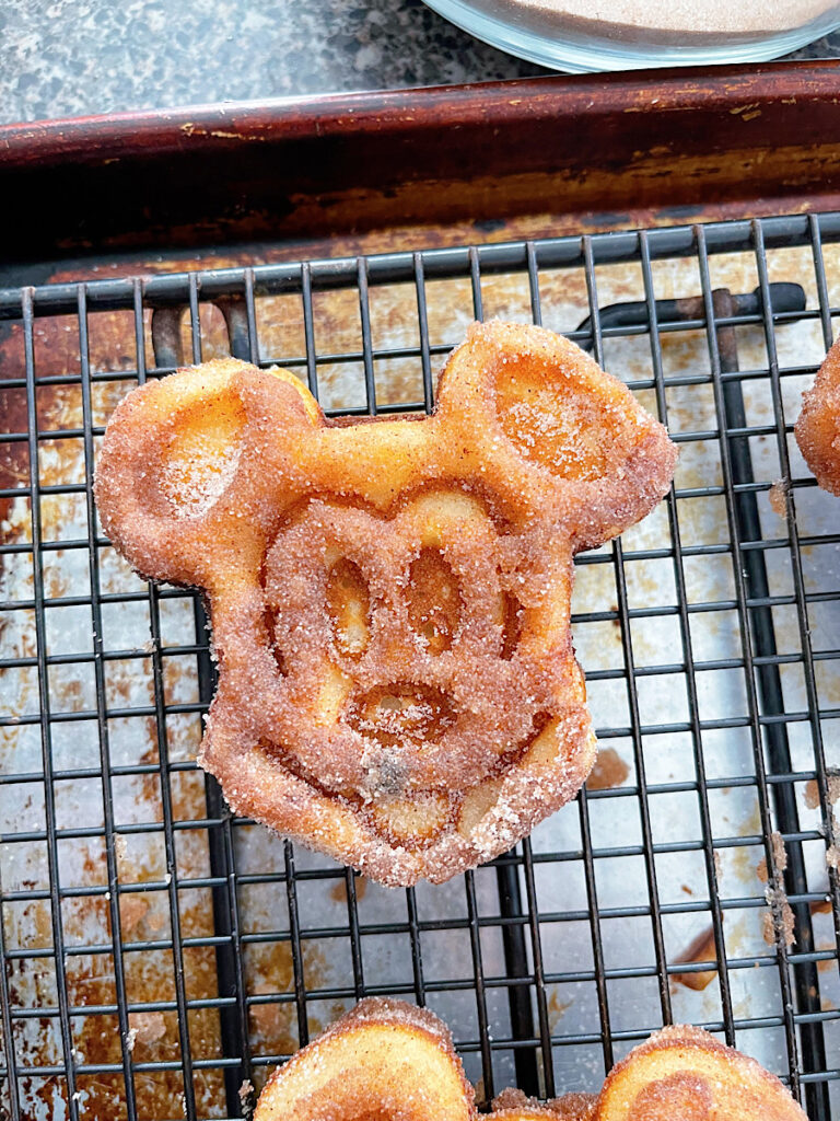 Churro Mickey waffles on a wire rack.