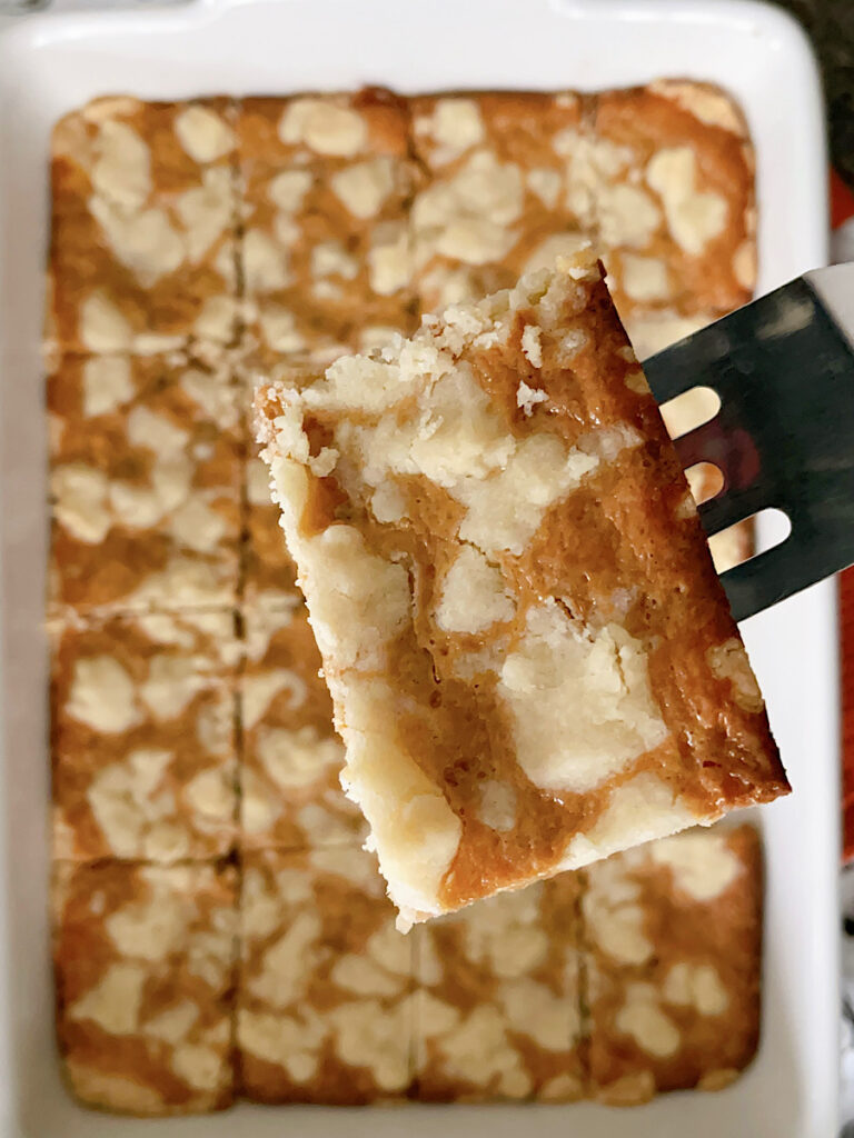 A caramel shortbread bar on a spatula.