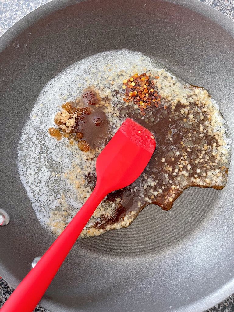 TikTok ramen sauce in a skillet with a red spatula.