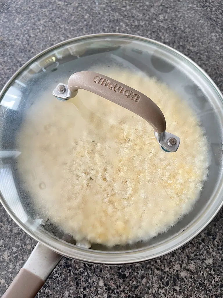 A lid on a pan of instant rice.