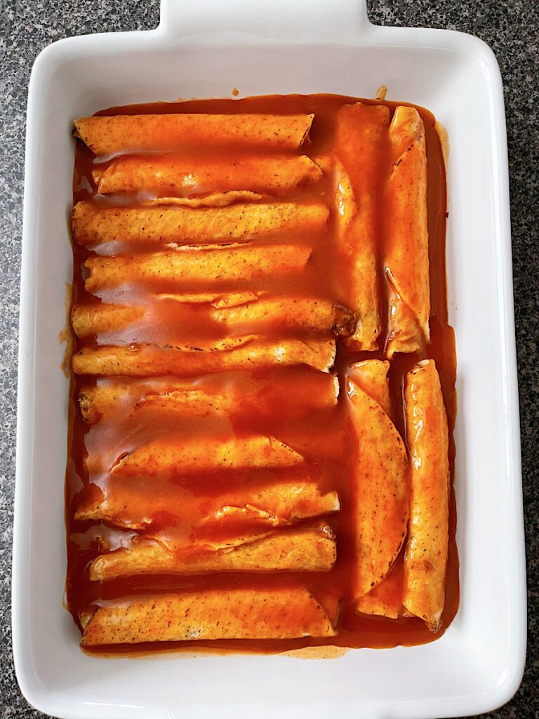 Frozen taquitos in a dish with enchilada sauce to make lazy enchiladas.