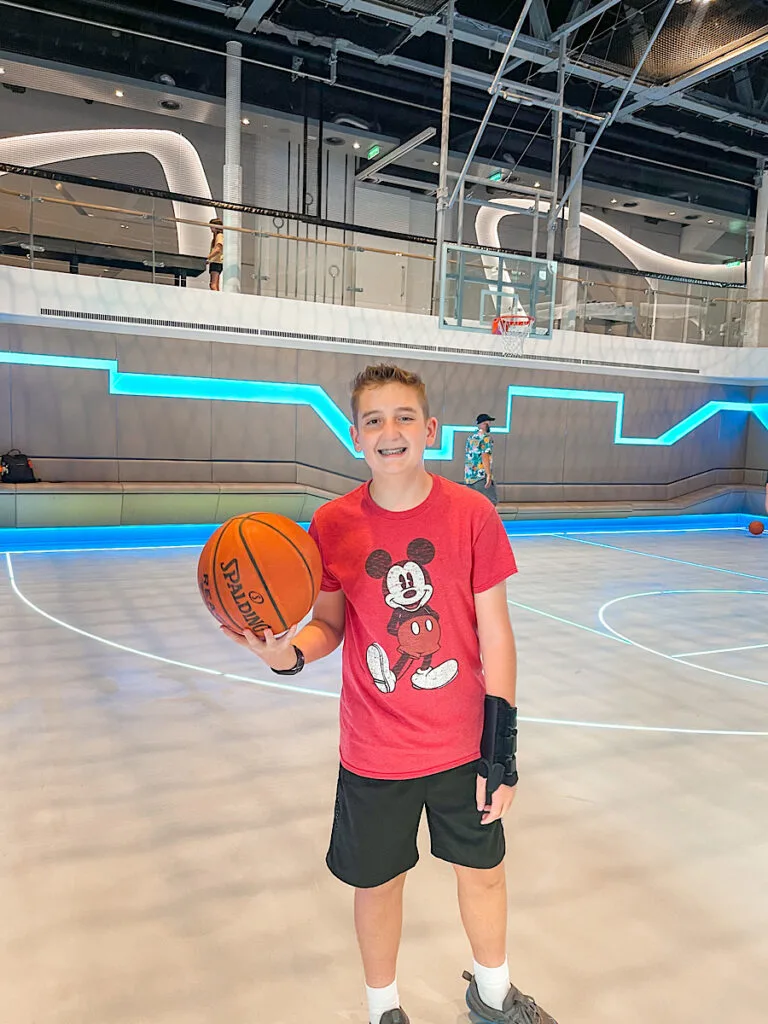 A teen inside the Hero Zone sports court on the Disney Wish.