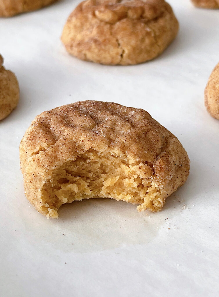 A pumpkin snicerdoodle cookie on parchment paper.