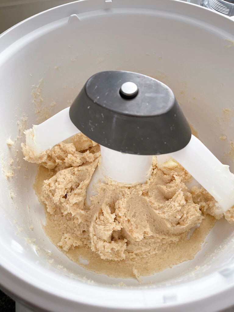 Butter mixed with sugar and brown sugar to make cookie dough.
