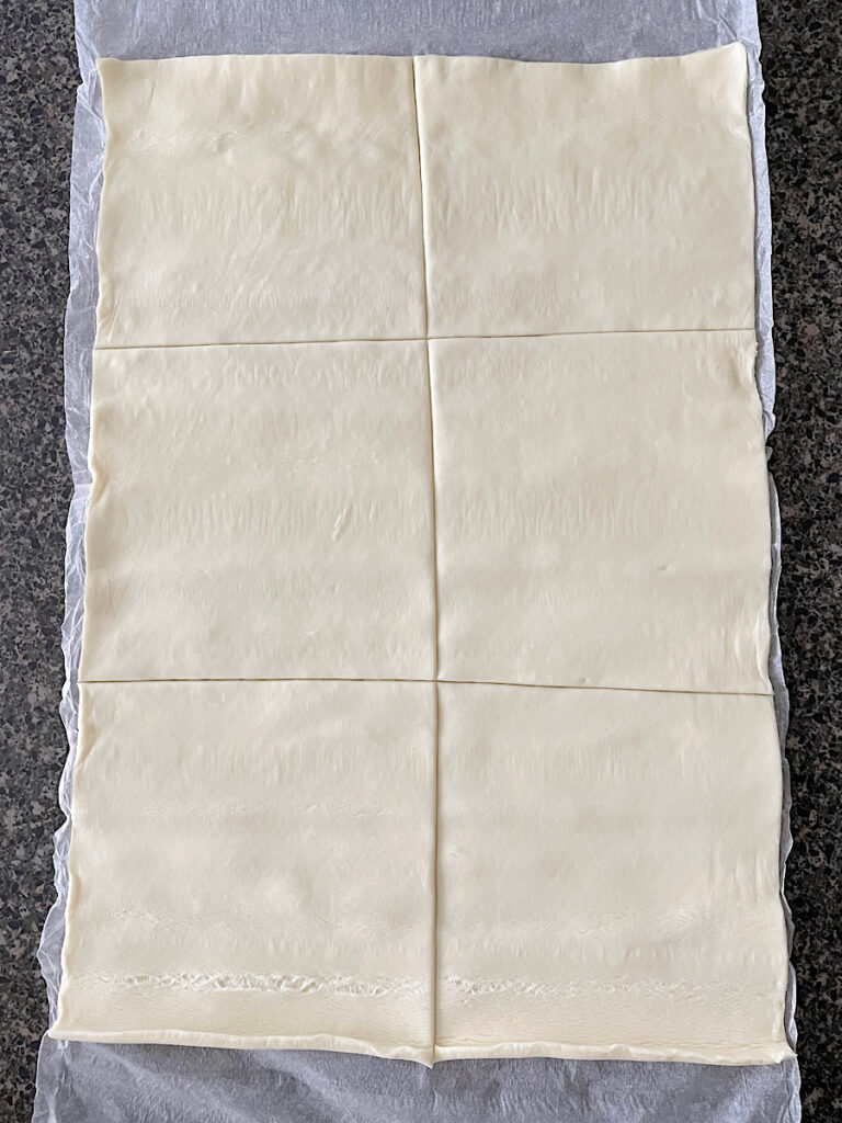 A puff pastry sheet cut into six squares.