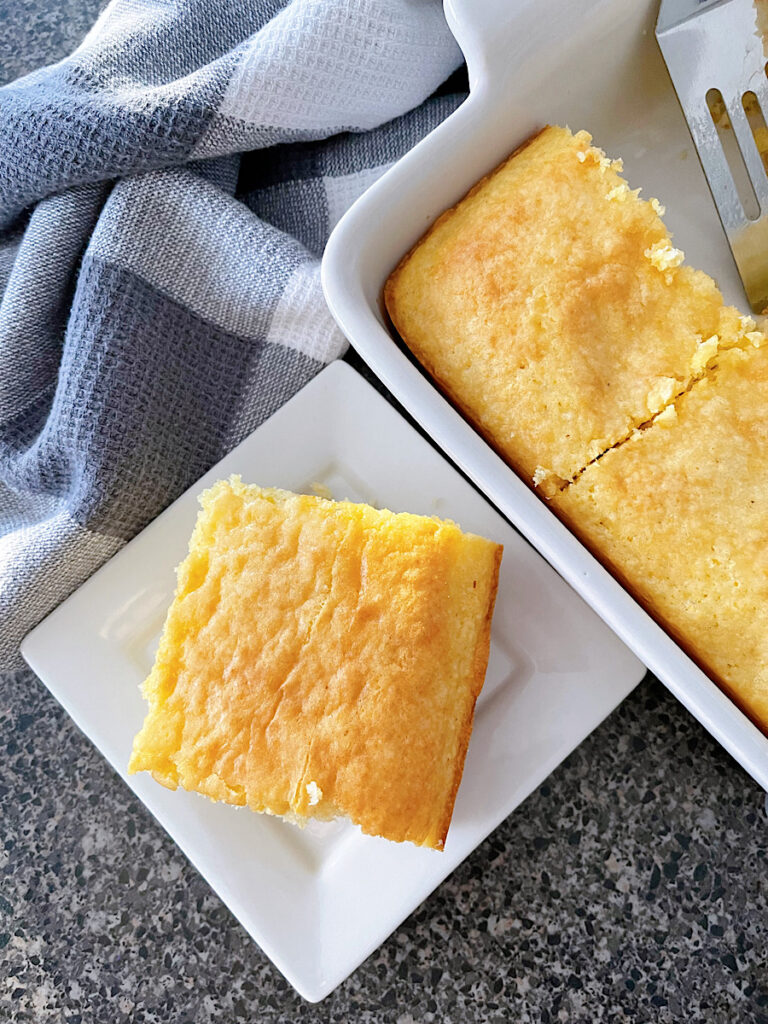 A slice of cornbread cake made with a yellow cake mix and Jiffy cornbread mix.