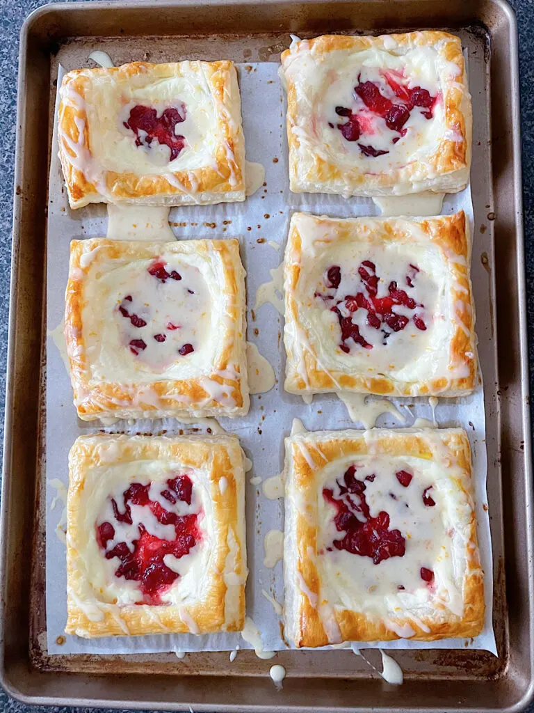 Cranberry cream cheese Danishes made with Puff Pastry dough and drizzled with orange glaze.