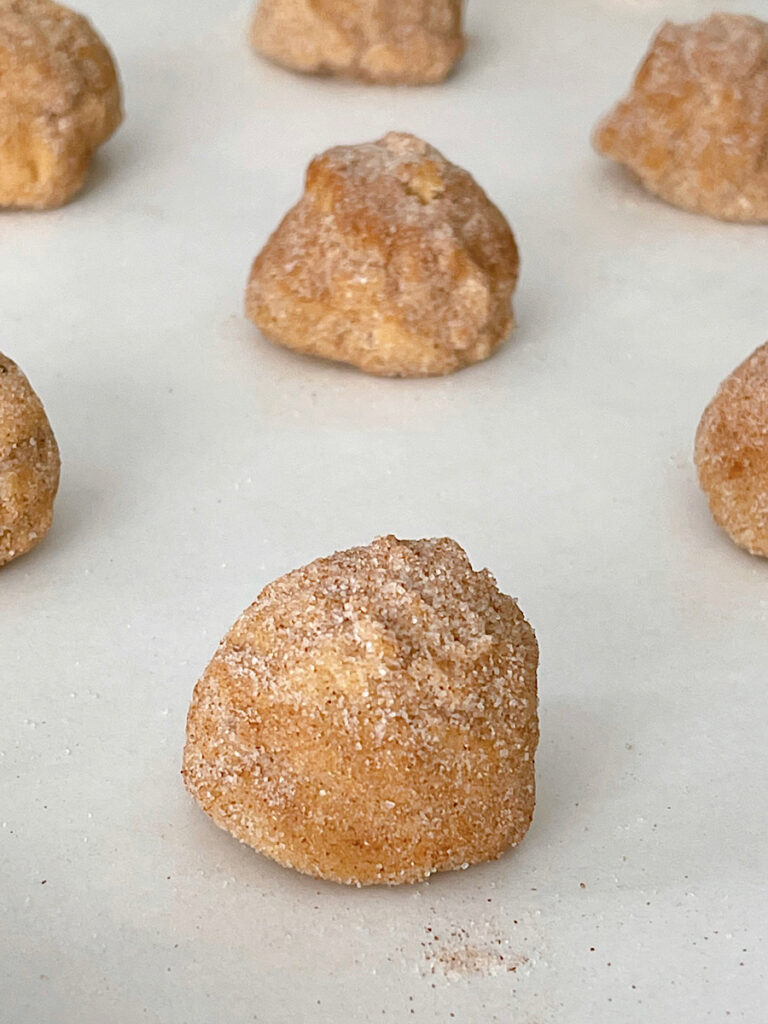 Pumpkin snickerdoodle cookie dough balls on a baking sheet.