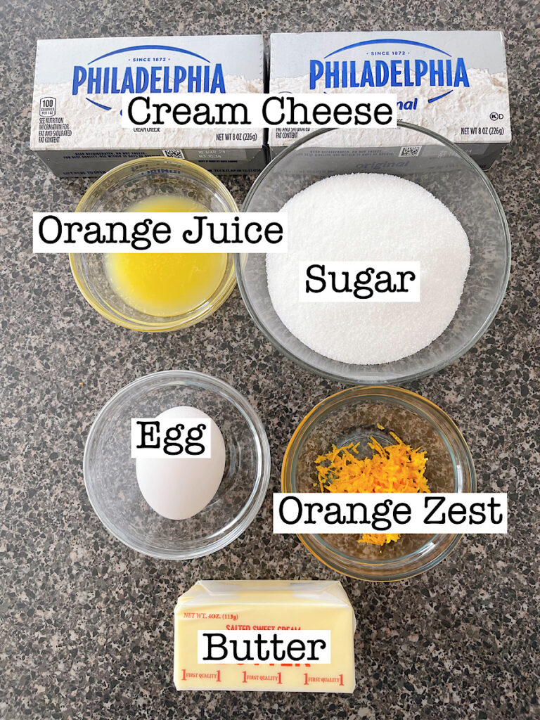 Ingredients to make orange cream cheese filling for orange rolls.