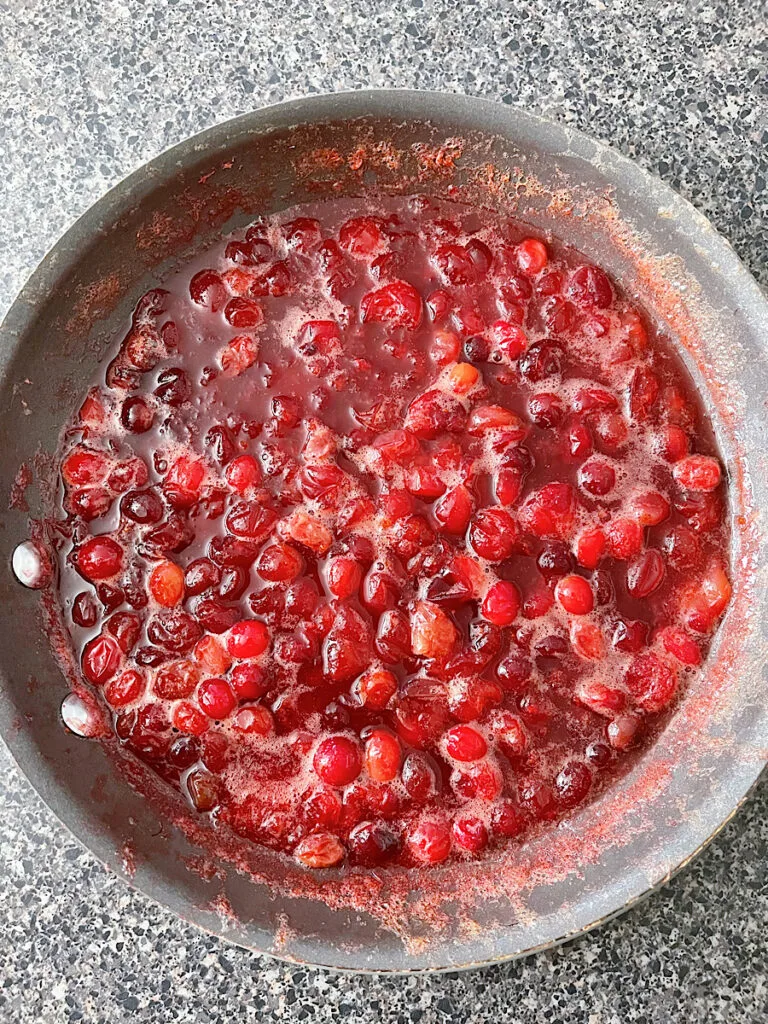 Cranberry sauce cooking in a sauce pan.