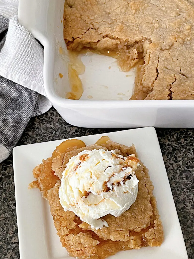 Apple Crisp made with apple pie filling on a white plate topped with a scoop of ice cream.