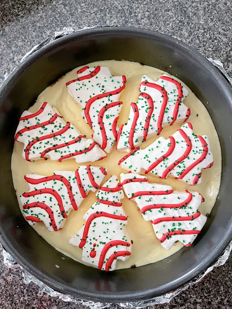 Cheesecake batter and Little Debbie Christmas Tree Cakes in a cheesecake pan.