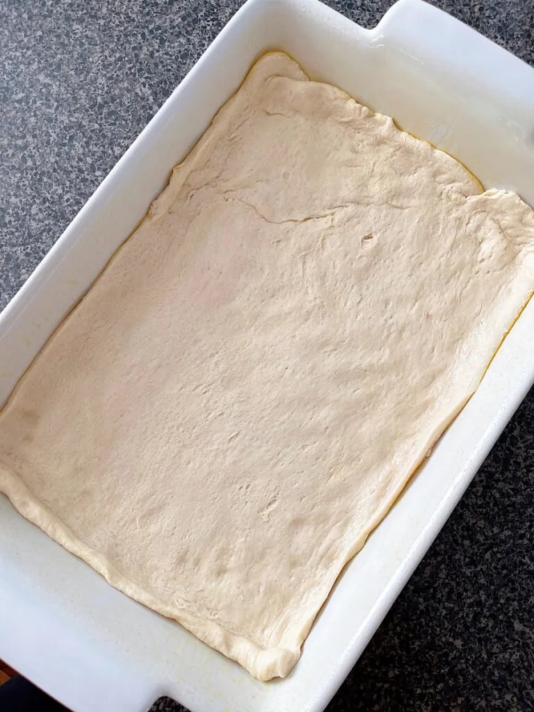 Crescent roll dough on the bottom of a baking dish.