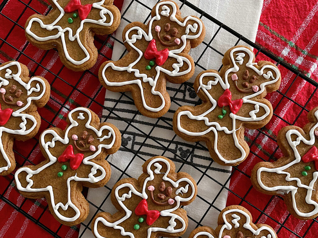 Soft gingerbread cookies decorated like Mickey Mouse on a cooling rack.