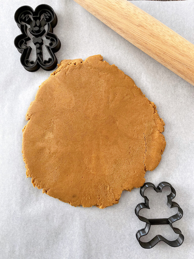 Gingerbread cookie dough rolled out with Mickey gingerbread man cookie cutters.