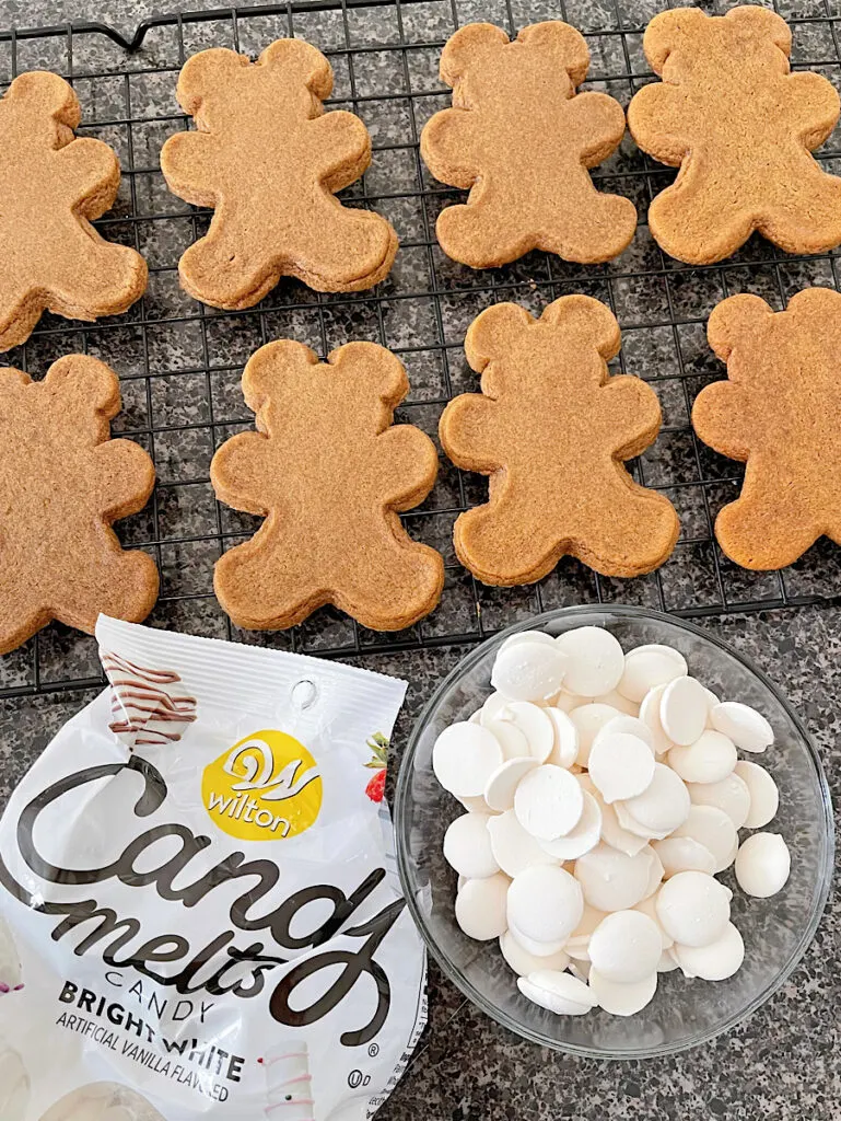 Mickey Mouse gingerbread man cookies and a bowl of white candy melts for decoration.