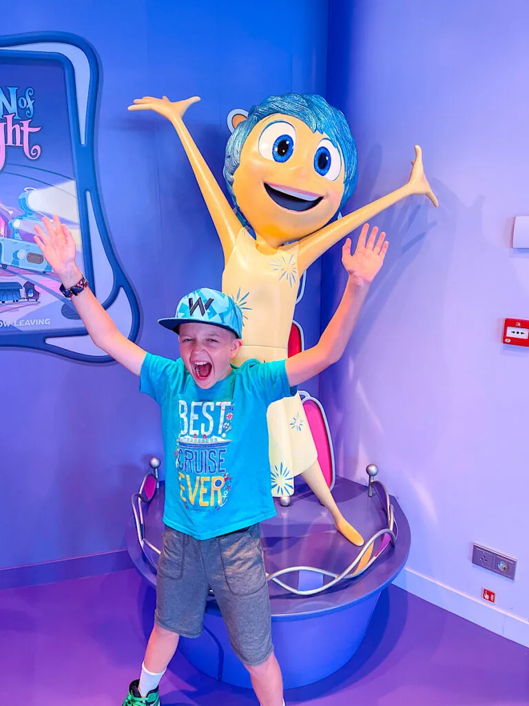 A child in front of Joy at Joyful Sweets on the Disney Wish.