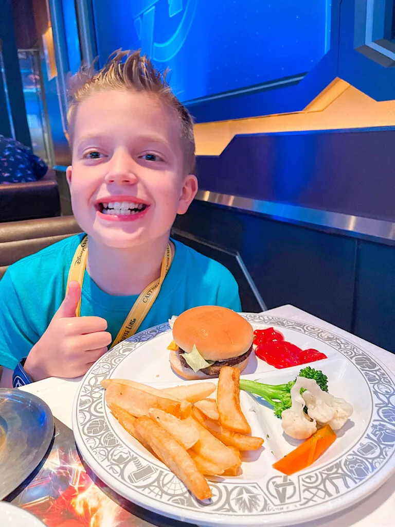 A child with a mini cheeseburger kids meal at Worlds of Marvel.