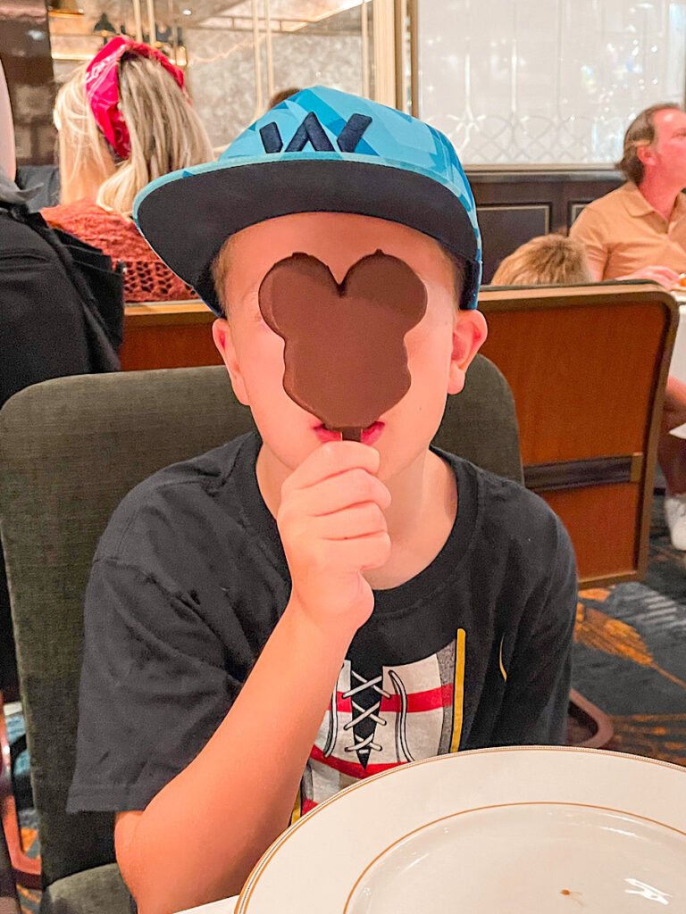 A child enjoying a Mickey Ice Cream Bar on the Disney Wish.