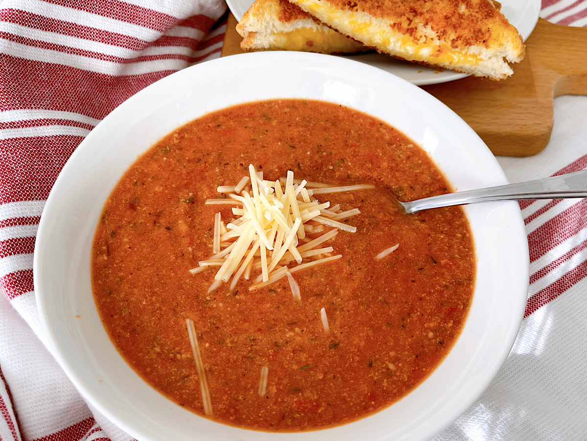 A bowl of tomato parmesan soup made with canned tomato sauce.