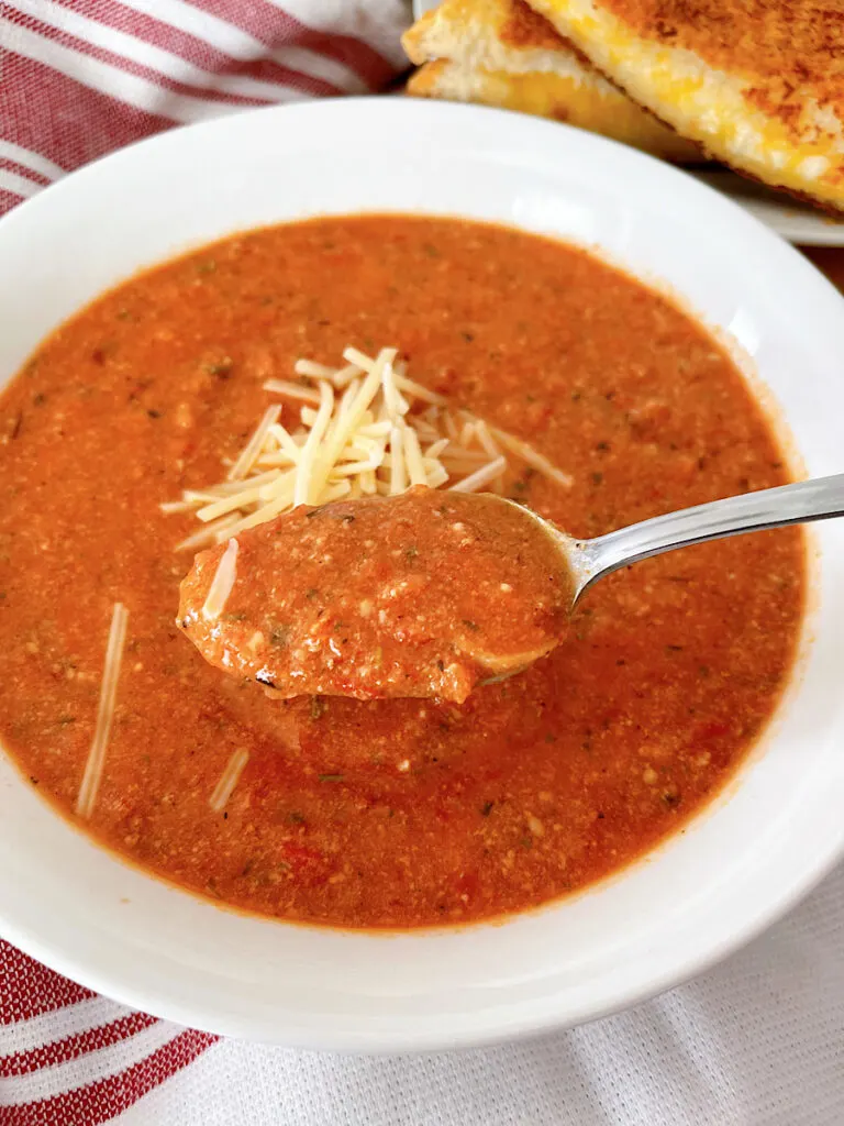 A bowl of tomato parmesan soup made with canned tomato sauce.