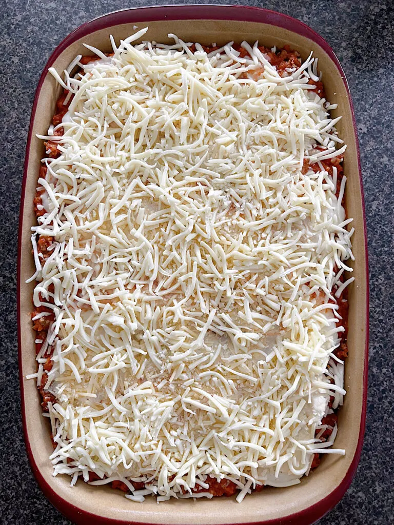 An unbaked bechamel lasagna in a baking dish.