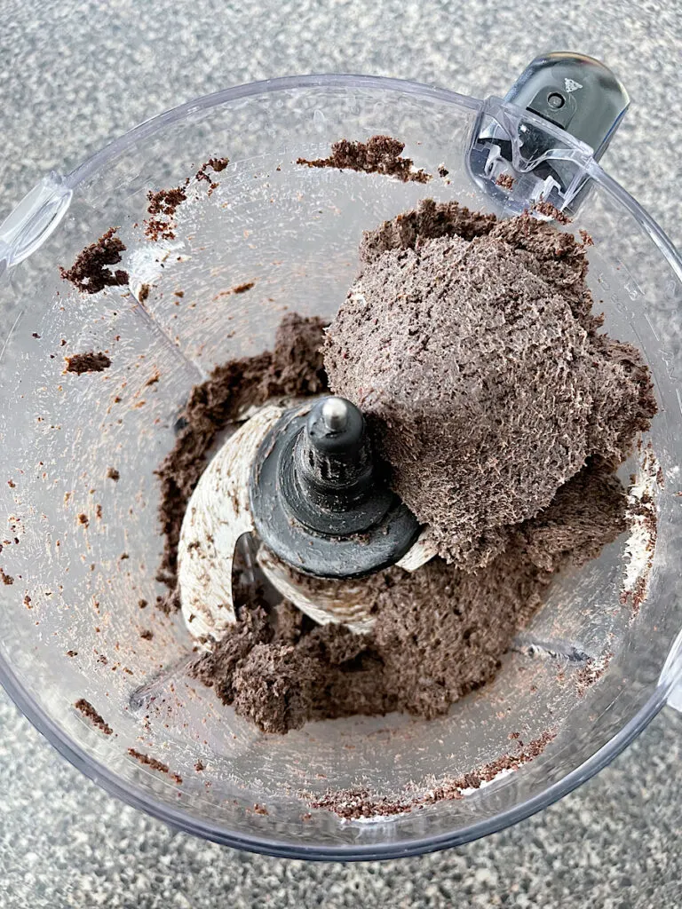Oreo crumbs mixed with cream cheese in a food processor.