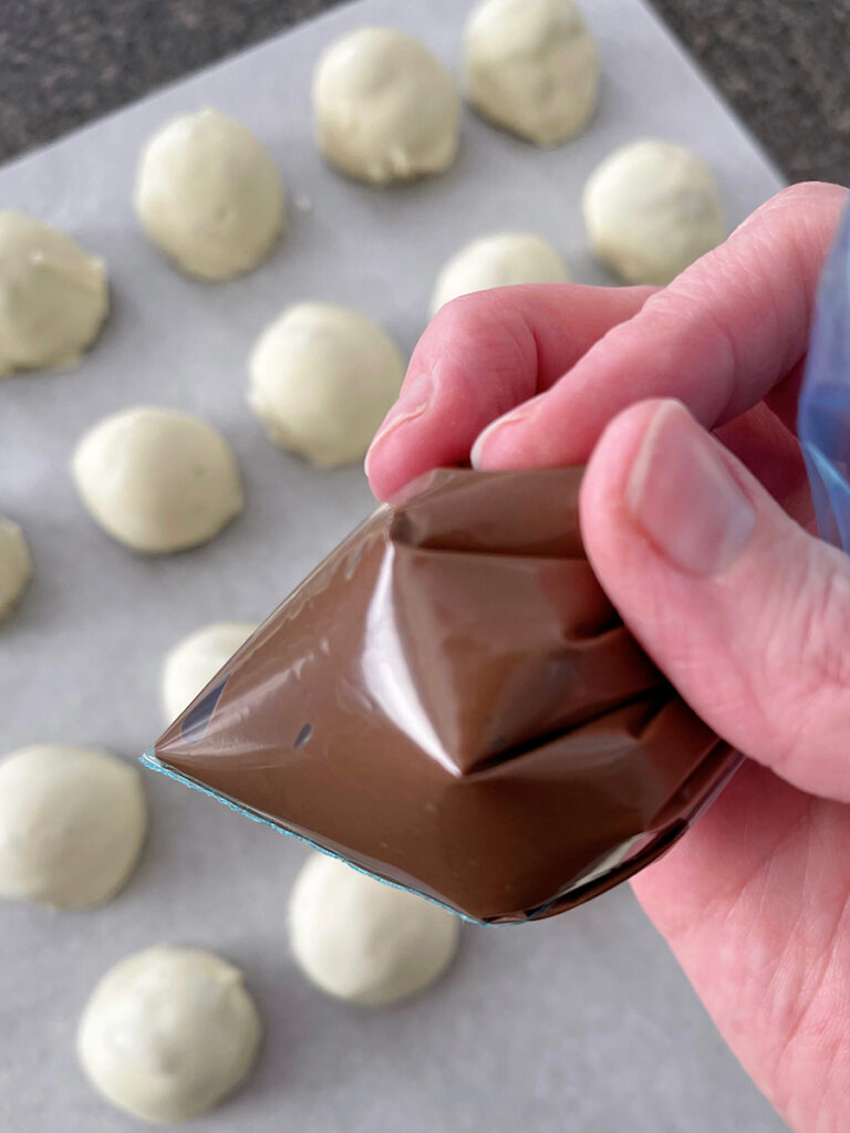 Melted chocolate in a ziplock bag to drizzle over OREO truffle balls.