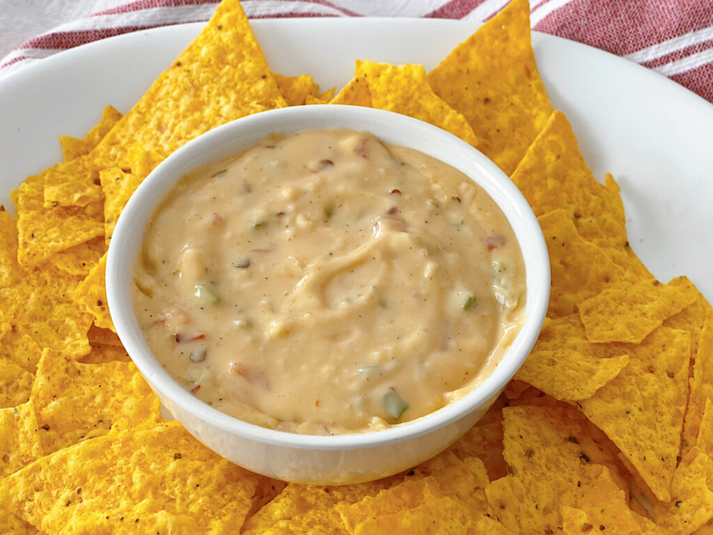 A bowl of homemade Chipotle queso blanco with tortilla chips.