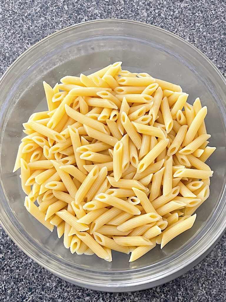 A bowl of cooked penne pasta.