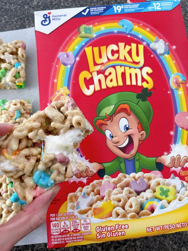 A Lucky Charms treat over a box of Lucky Charms.