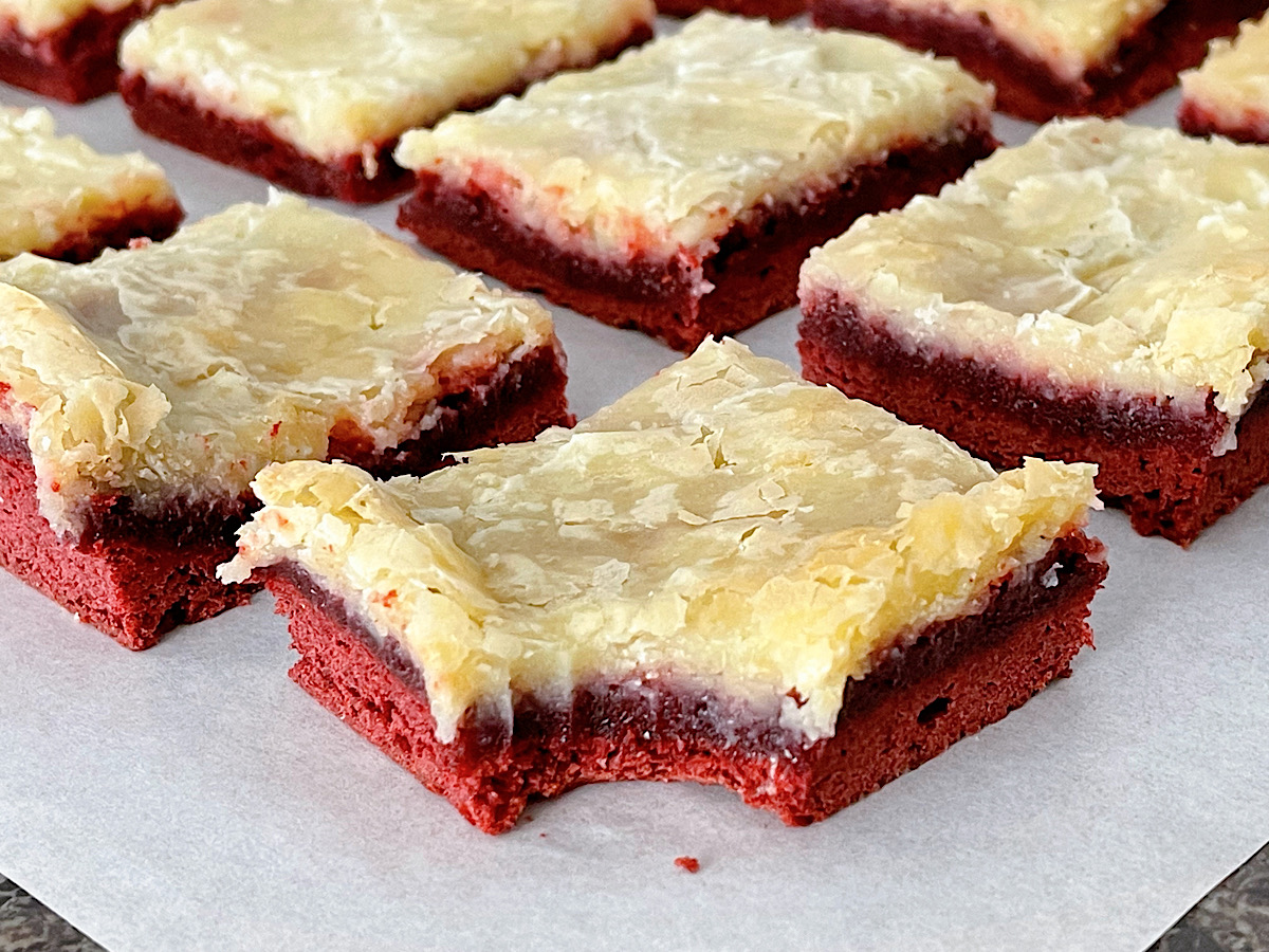 A red velvet ooey gooey bar with a bite taken out.