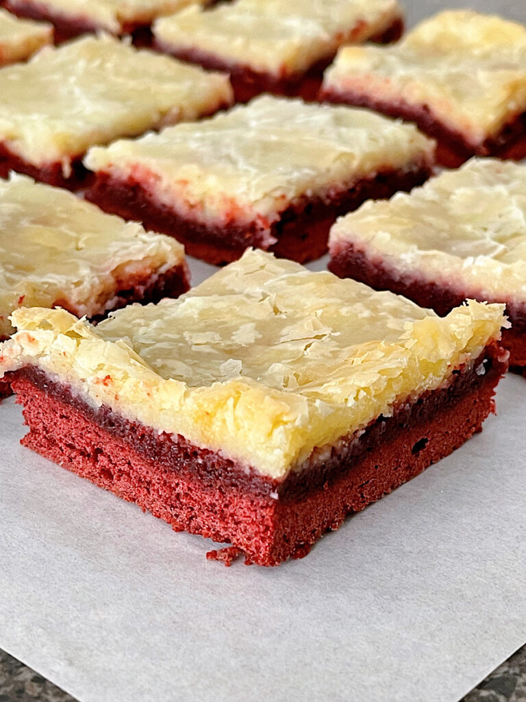 Red Velvet cream cheese bars on parchment paper.