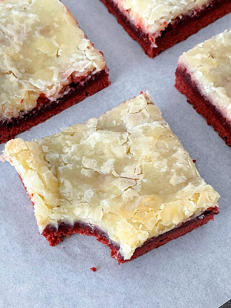 A red velvet ooey gooey bar with a bite taken out.