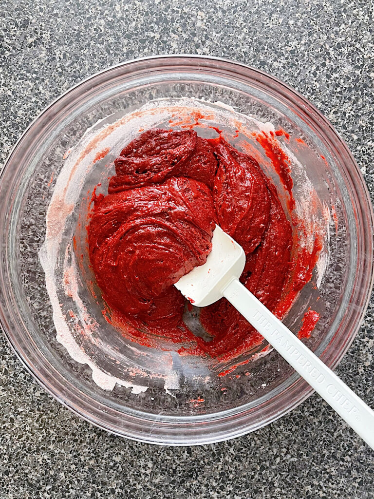Red velvet brownie batter in a mixing bowl.