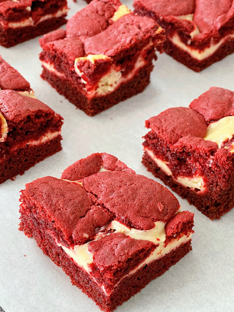 Red velvet cheesecake brownies on parchment paper.