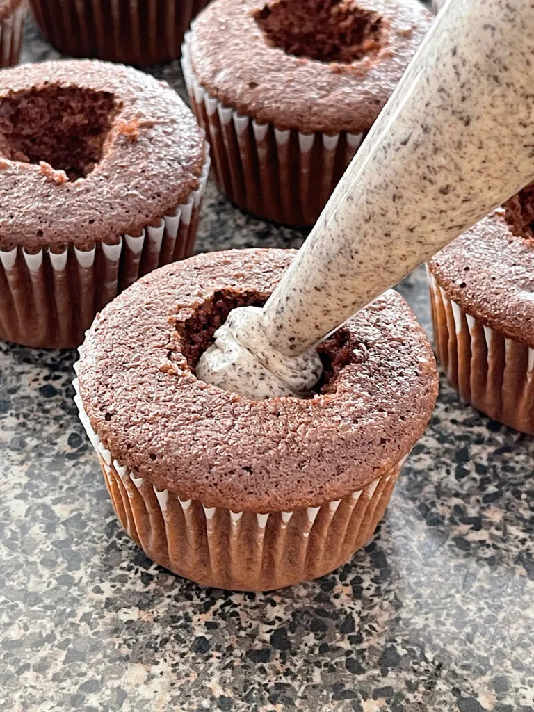 Oreo cheesecake filling piped into chocolate cupcakes.