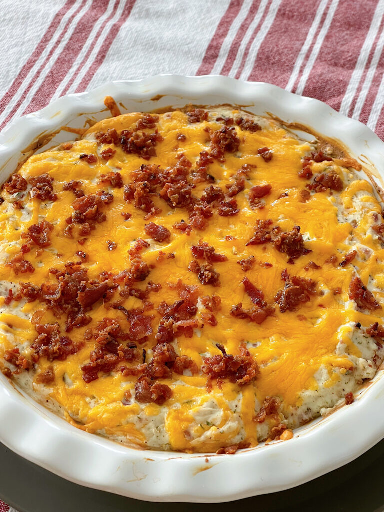 Warm crack chicken dip topped with cheese and bacon.