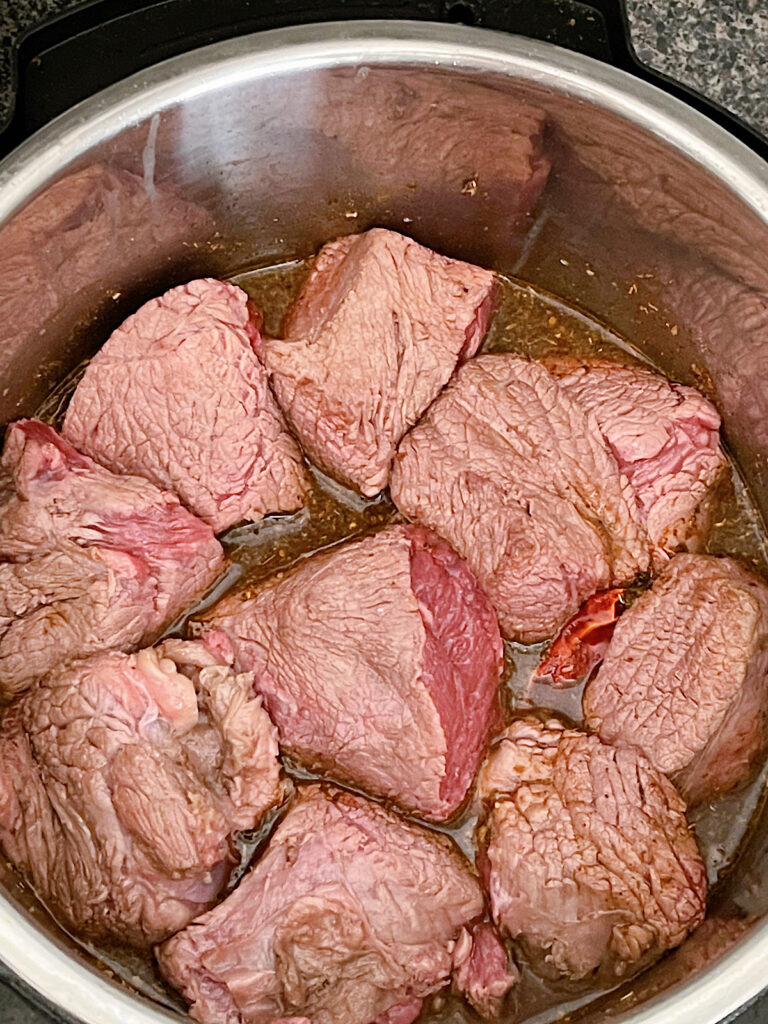 Beef chuck roast in an Instant Pot with spices to make beef birria.