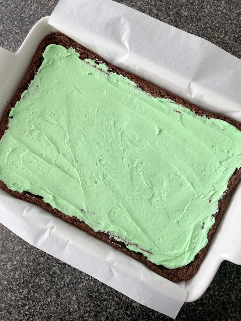 Brownies topped with mint frosting in a baking dish.