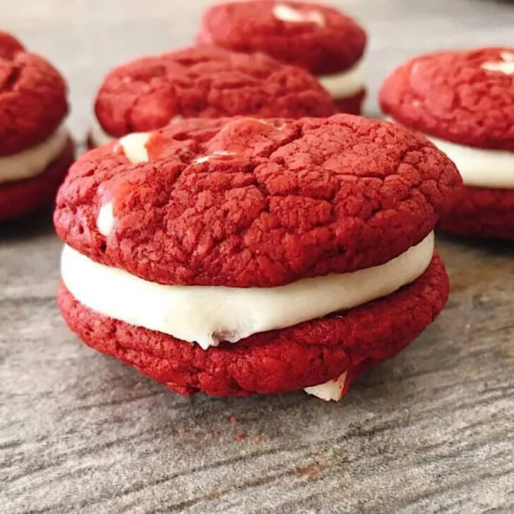 Two red velvet cake mix cookies sandwiched around cream cheese frosting.