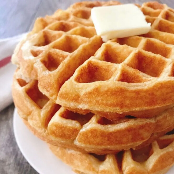 A stack of sweet cream waffles topped with butter.